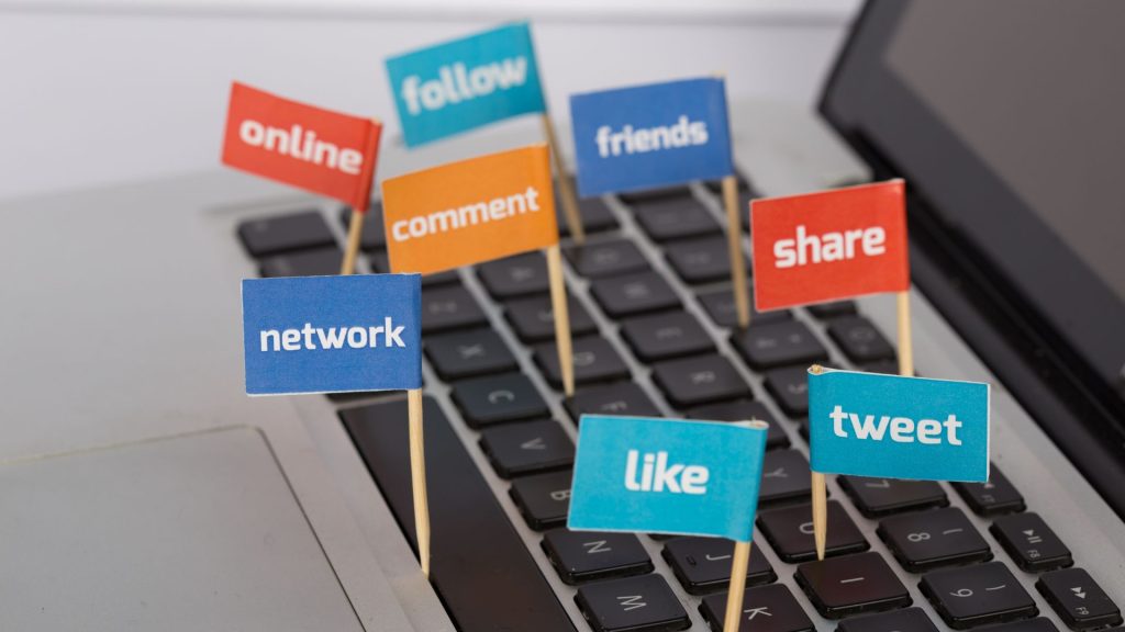 social media words on a keyboard on toothpicks with little banners such as Like, Friends, Share