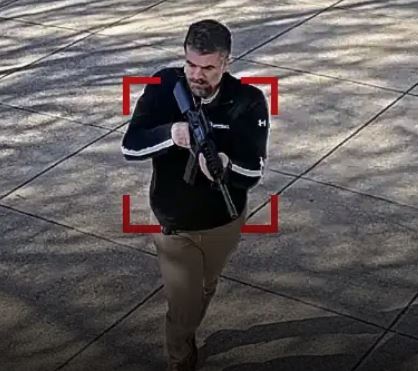 man holding fire arm entering building and up to no good.